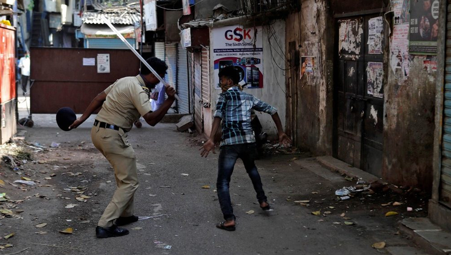  11 aprile 2020 | Mumbai, India | Un poliziotto brandisce il manganello verso un uomo per aver infranto il coprifuoco. Sarebbero morte almeno 15 persone a causa di percosse o fustigazioni da parte della polizia