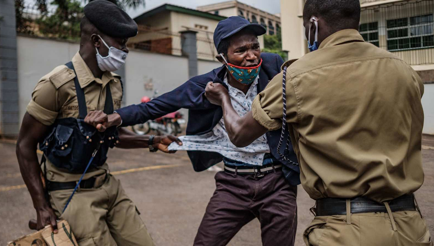 Maggio 2020 | Kampala, Uganda | Un manifestante viene arrestato dalla polizia durante una protesta per una maggiore distribuzione di cibo da parte del governo durante la crisi di Covid-19 (Sumy Sadurni/AFP via Getty Images)